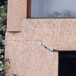 Une fissure montante en escalier et traversante l'ouverture du garage en façade Nord. Des jauges ont été mis en place afin de suivre l'évolution des désordres